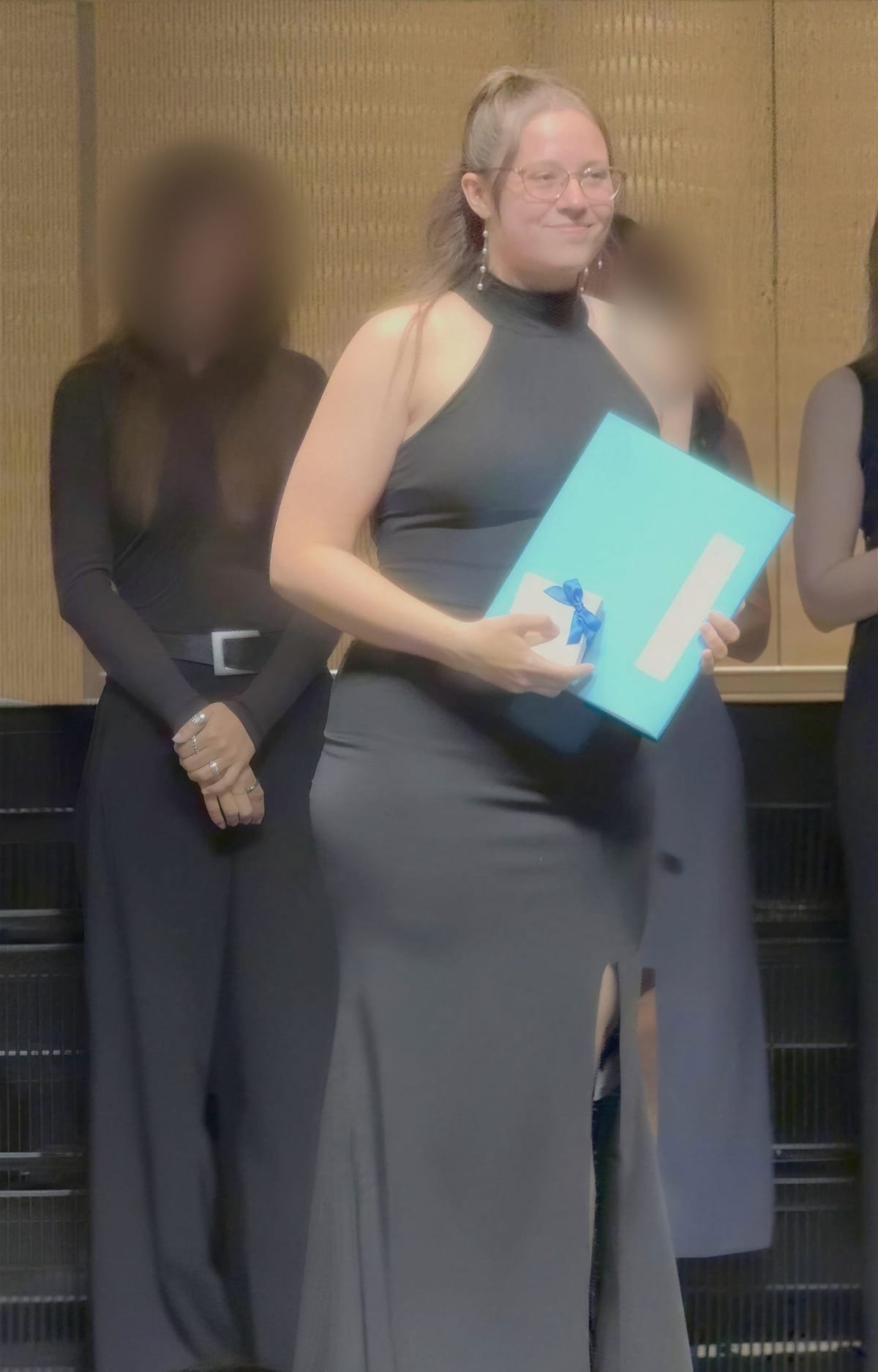 Noemi Debellis on stage at the ZHAW graduation ceremony, other faces blurred