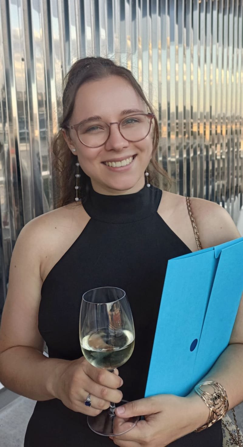 Noemi Debellis with her diploma folder at the graduation celebration